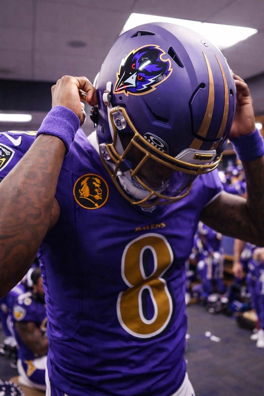 Lamar Jackson putting on Ravens helmet